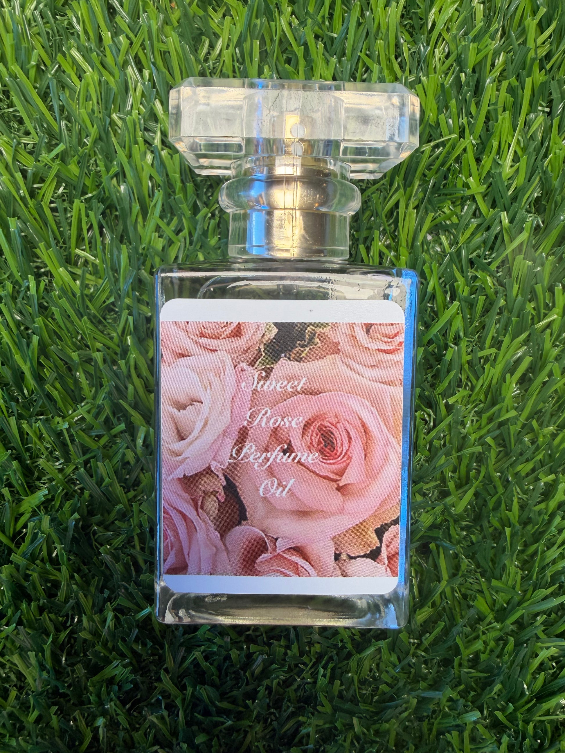 Beauty For Ashes Perfume Oil by LOVEBYEMMASKINCARE with fresh cut rose scent, featuring a sleek glass bottle and floral accents.